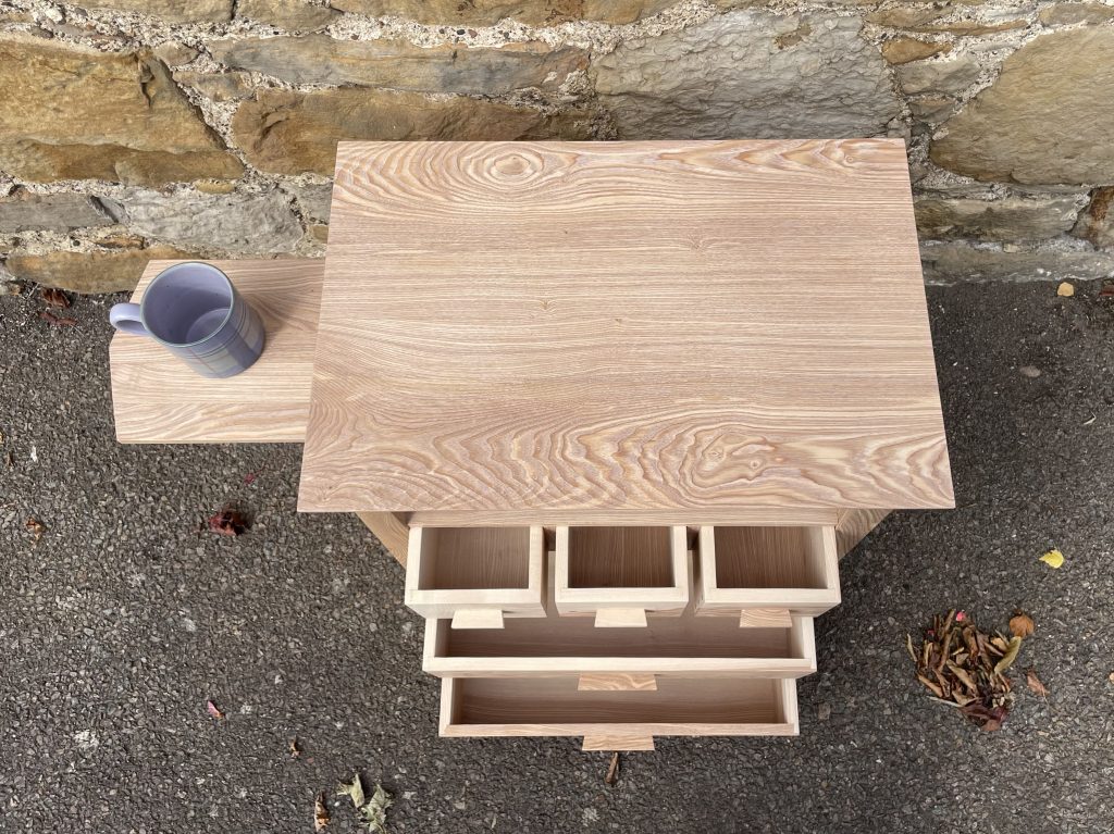 "Chaffinch" bedside cabinet made by Iain Stirling of Chapelhill Fine Furniture. View of extended tray and all drawers open.