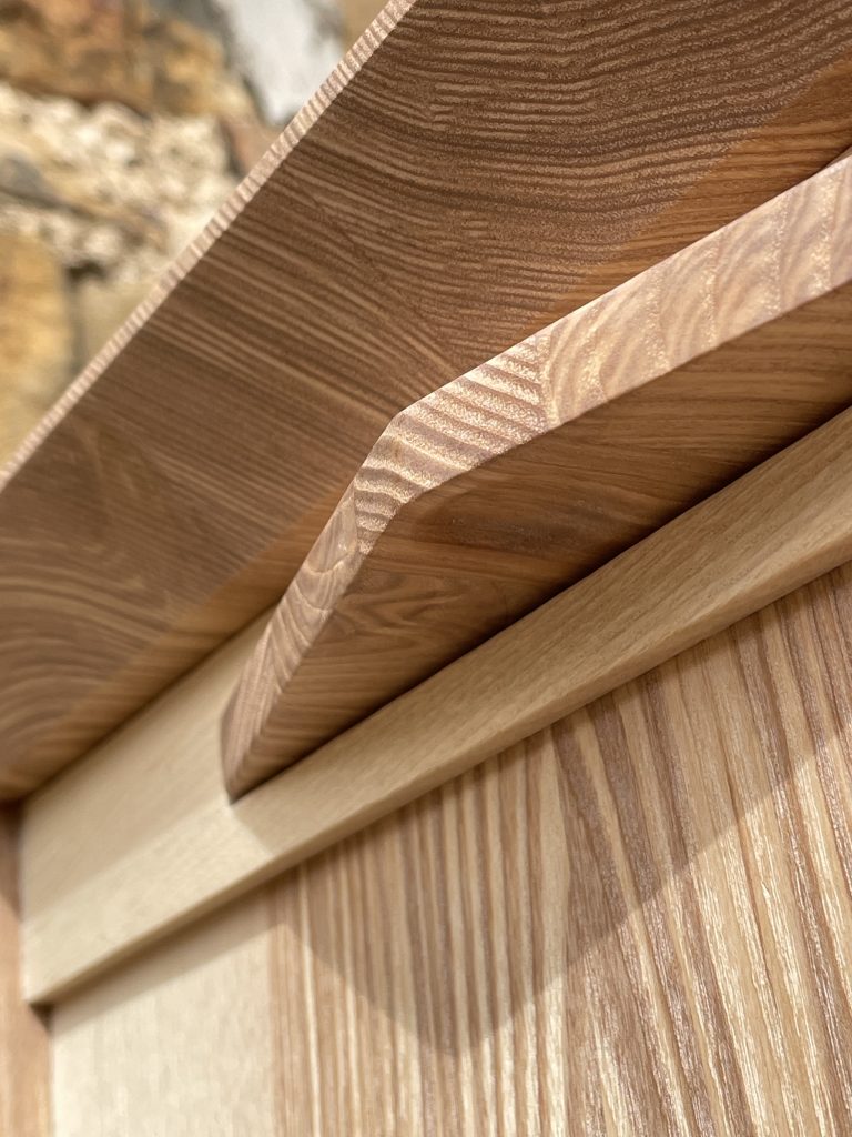 "Chaffinch" bedside cabinet made by Iain Stirling of Chapelhill Fine Furniture. View of concave dimple on underside of tray for finger pull.