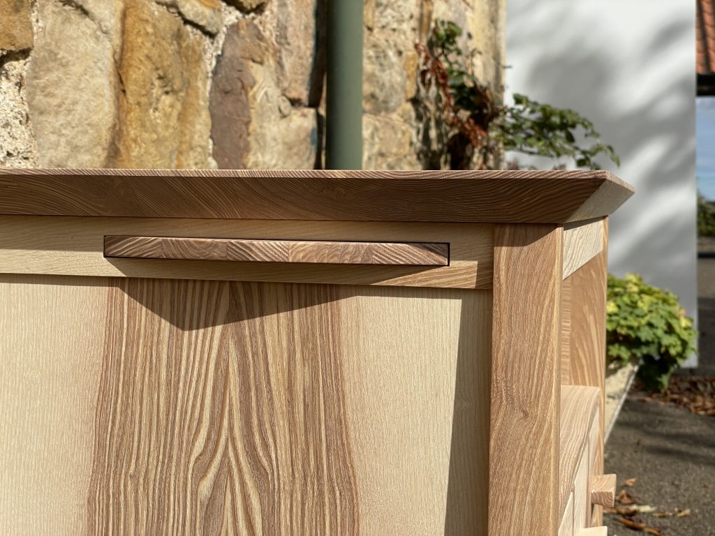 "Chaffinch" bedside cabinet made by Iain Stirling of Chapelhill Fine Furniture. Close-up side view of tray opening.