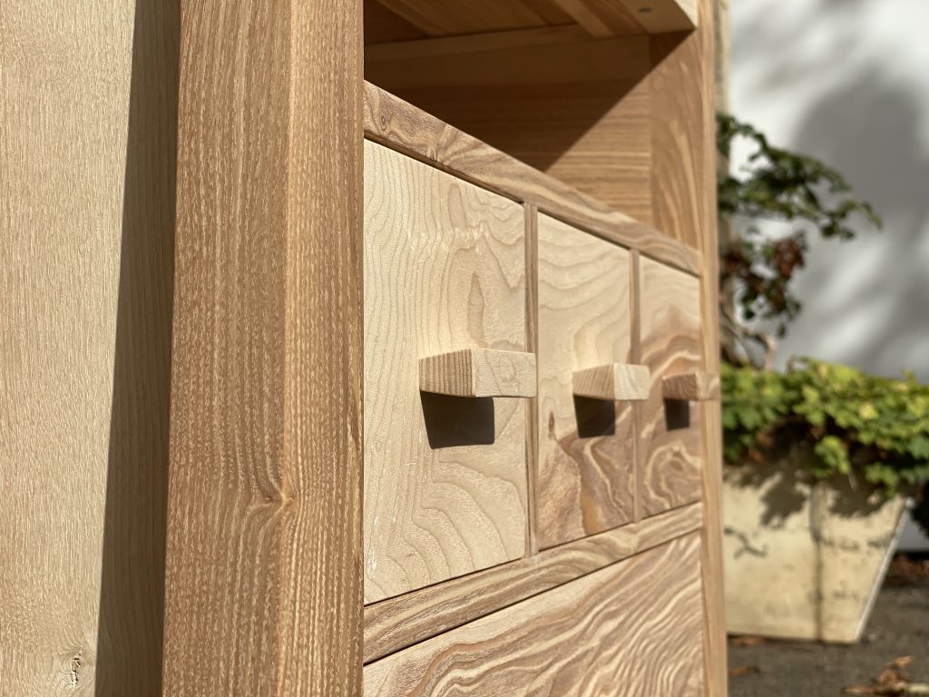 "Chaffinch" bedside cabinet made by Iain Stirling of Chapelhill Fine Furniture. Close-up side view of drawer fronts.