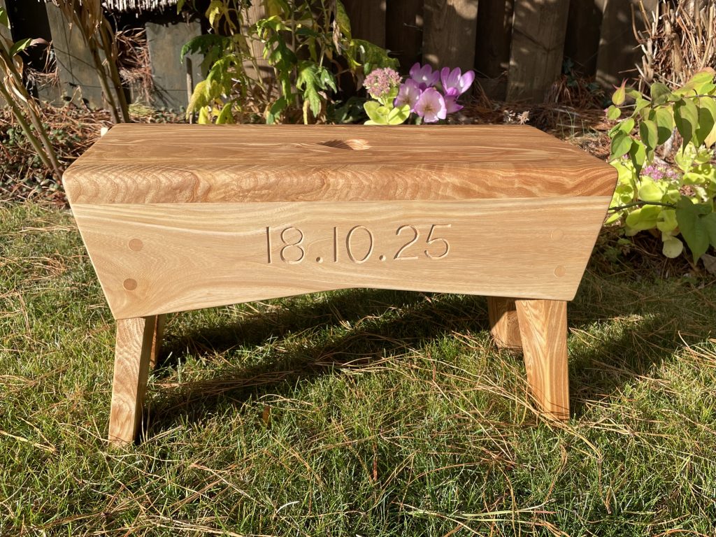 Heart shaped finger-hole in the top of a creepie stool made from olive ash and elm.