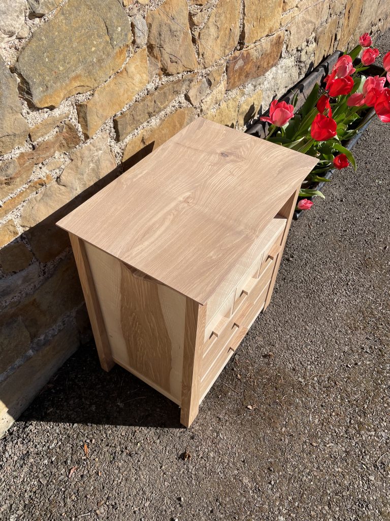 Picture of a "Chaffinch" Bedside Cabinet in olive ash.  Bespoke furniture made by Iain Stirling of Chapelhill Fine Furniture.