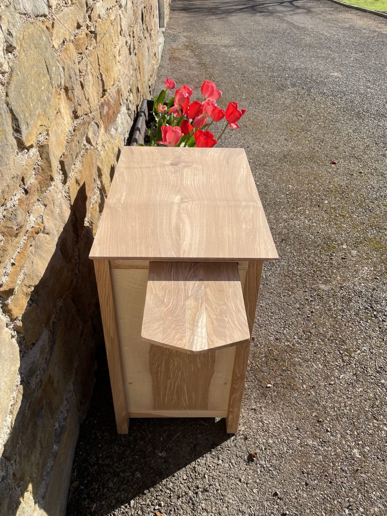 Picture of a "Chaffinch" Bedside Cabinet in olive ash.  Bespoke furniture made by Iain Stirling of Chapelhill Fine Furniture.