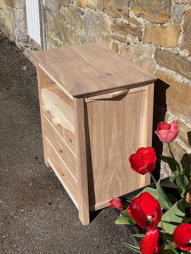 Picture of a "Chaffinch" Bedside Cabinet in olive ash.  Bespoke furniture made by Iain Stirling of Chapelhill Fine Furniture.