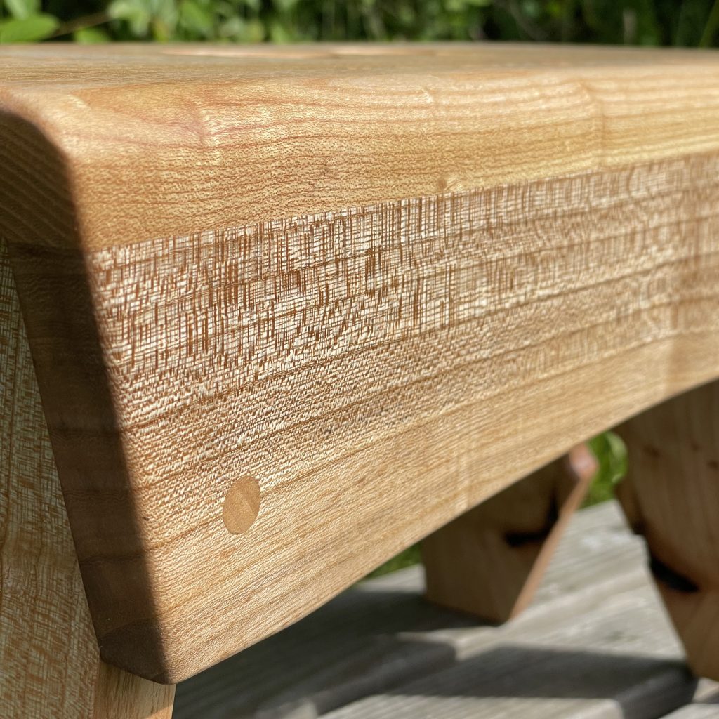 Scottish creepie stool in elm, with double-heart finger holes, made by Chapelhill Fine Furniture.