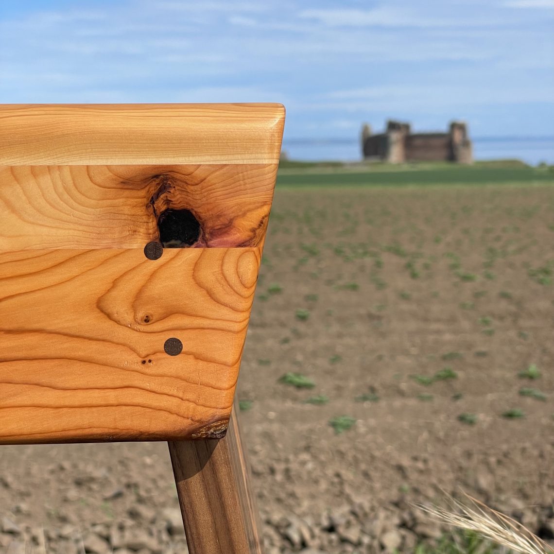 Close-up of yew and walnut Scottish creepie stool made by Chapelhill Fine Furniture in Scotland.
